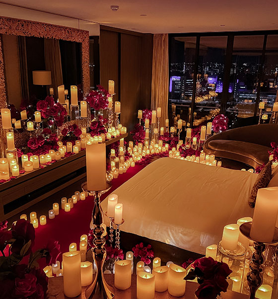 Candles and roses fill a room, casting a warm glow and adding a touch of romance in Brisbane.